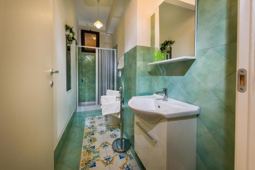 bagno con lavandino e specchio di Appartamenti il Patio a San Vito lo Capo