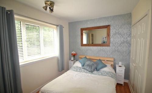 a bedroom with a bed with a mirror and a window at Doncaster - Boswell - Large Balcony Apartment & Parking - 2 Bedrooms - Close to Town & Racecourse in Doncaster