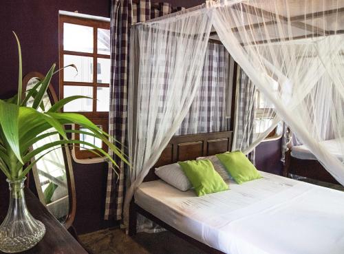 een slaapkamer met een bed met een klamboe bij Villa Taprobane in Negombo