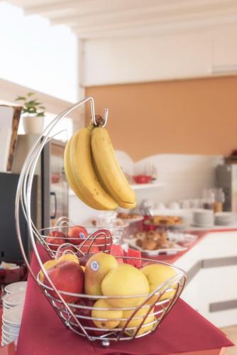 a basket of fruit on a counter with bananas at Hotel Flora in Noto