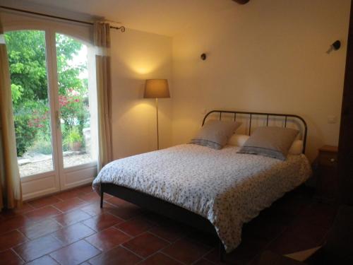 La Motte-dʼAiguesにあるLa mordoréeのベッドルーム1室(ベッド1台、大きな窓付)