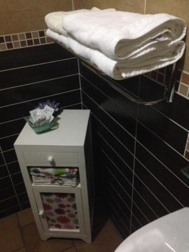 a bathroom with a toilet and a towel on a shelf at Hotel Rural El Cuco in Ribatajadilla