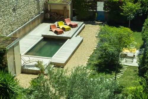 フルーリーにあるLa Maison des Vendangeurs 2のプールとラウンジチェア付きの裏庭の景色を望めます。