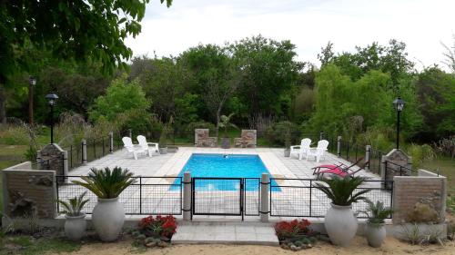 a swimming pool with white chairs and a pool at Guidai Bilu in San José