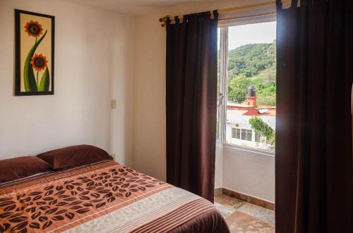 a bedroom with a bed and a window with a view at Hospedaje Casa Verde in Tepoztl&aacute;n