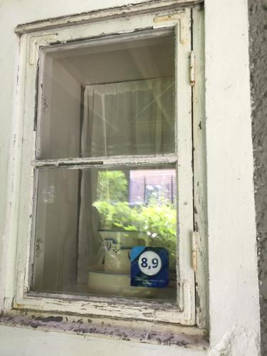 an open window with a potted plant and a smiley face at Domsjö Apartment in Örnsköldsvik