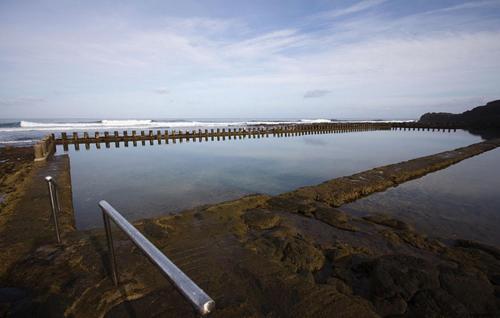 a large body of water with a pier and the ocean at Casa Playa Ondina in Gáldar