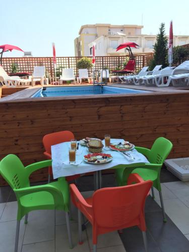 a table and chairs with food and drinks on a patio at Sunrise Hotel Cameria in Durrës