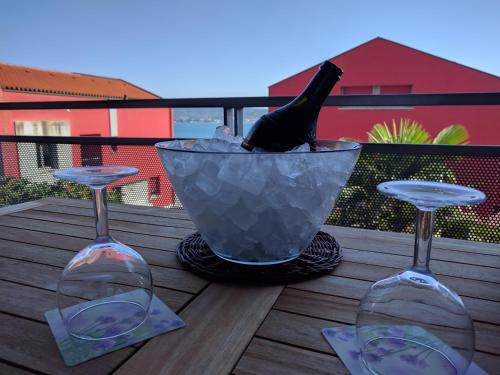 three wine glasses sitting on a table with a wine bottle at Jan's Place at Seaside in Ankaran