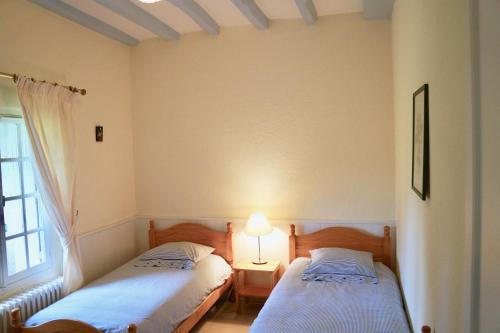 dwa łóżka w pokoju z oknem i lampką w obiekcie Les Hauts de Chaume w mieście Génillé