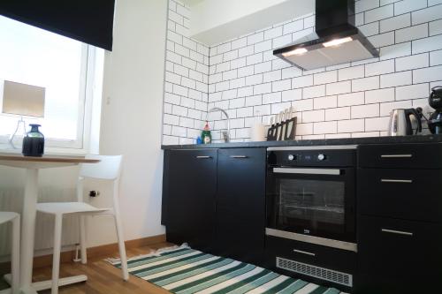 a kitchen with black cabinets and a black oven at Easy Livin' Apartment Hotel in Växjö