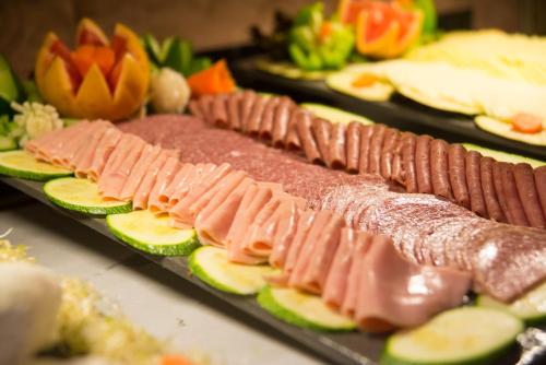 un buffet de comida con carnes y verduras en los platos en Occidental Cozumel - All Inclusive, en Cozumel