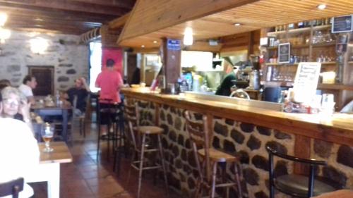 un bar dans un restaurant avec des tables dans l'établissement Chambres d'hôtes du Rebemol, à Le Monastier sur Gazeille