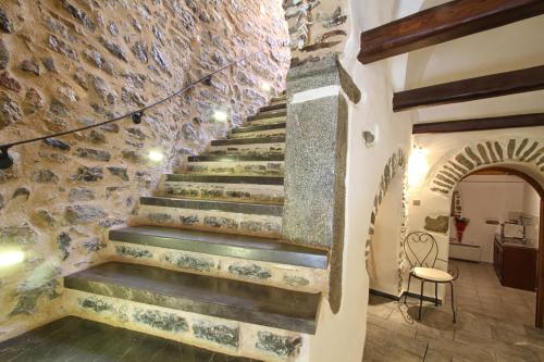 a staircase in a house with a stone wall at Schinos Apartments in Mesta