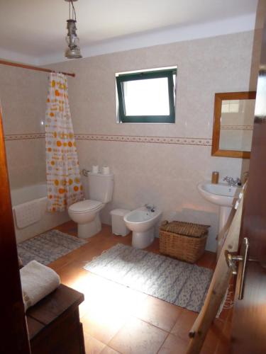 a bathroom with two toilets and a tub and a sink at Refugio da Maceira in Marvão