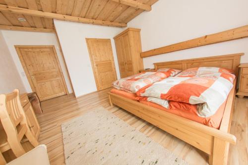a bedroom with a bed and wooden floors and wooden ceilings at Landgasthof Seyrlberg in Reichenau im Mühlkreis