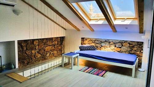 a bedroom with a bed and a stone wall at Apartment Vrbenka in Vrbnik