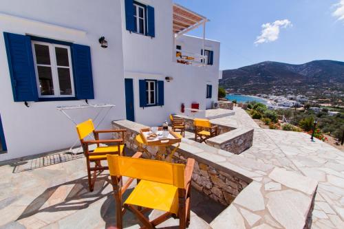 a table and chairs on a patio with a view at Venikouas Hotel in Platis Yialos Sifnos