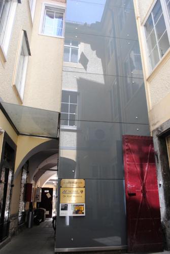 a glass building with a red door on a street at Sixties Appartement in Graz
