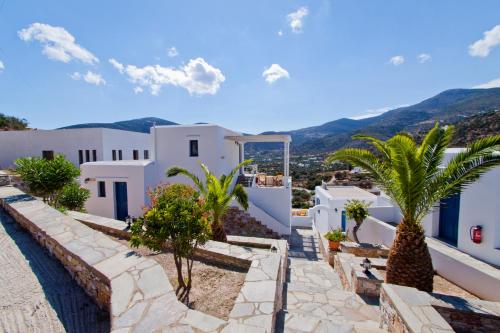 a view of a white building with palm trees at Venikouas Hotel in Platis Yialos Sifnos