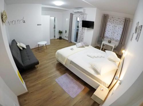 a bedroom with a bed and a chair and a couch at Guesthouse Villa DomeNico in Lozovac