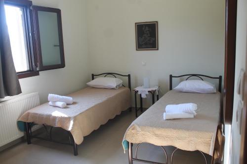 two beds in a room with a mirror at Villa Bene in Preveza