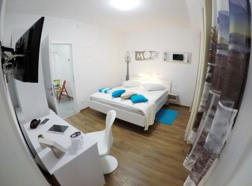 a bedroom with a bed and a desk with a tv at Guesthouse Villa DomeNico in Lozovac