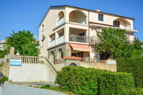 a large house with a staircase leading up to it at Apartments Dada in Senj