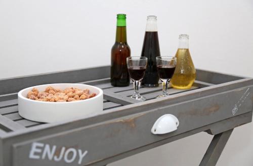 a tray with a bowl of peanuts and two bottles of wine at Guesthouse Villa DomeNico in Lozovac