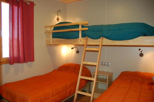 two bunk beds in a room with a ladder at Càmping Terra Alta in Bot