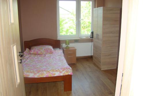 a small bedroom with a bed and a window at Ostoja Becejły in Szypliszki