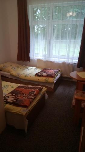 3 camas sentadas en una habitación con ventana en Hostel Dworek Osiecki KORAL, en Osieki