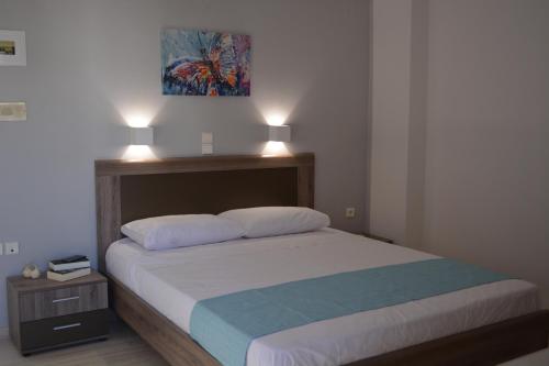 a bedroom with a bed with two lamps on top at Thegaia Studios in Rethymno Town
