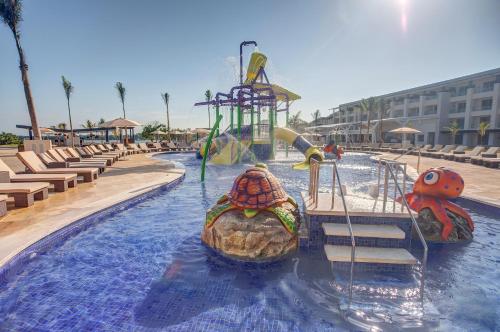 a pool with two rides in a resort at Royalton Negril, An Autograph Collection All-Inclusive Resort in Negril