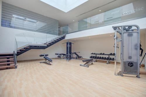 a gym with treadmills and a staircase in a room at Royalton Negril, An Autograph Collection All-Inclusive Resort in Negril