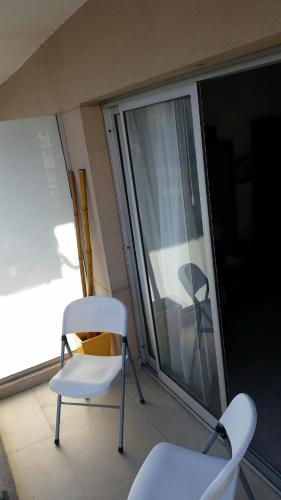two chairs sitting on a balcony next to a window at Palermo Quenns - Apartament Premiun in Buenos Aires