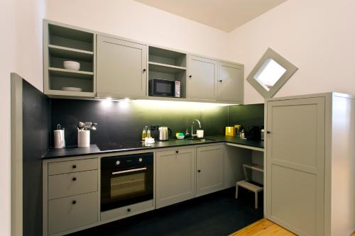 a kitchen with white cabinets and a stove top oven at Trait House in Porto