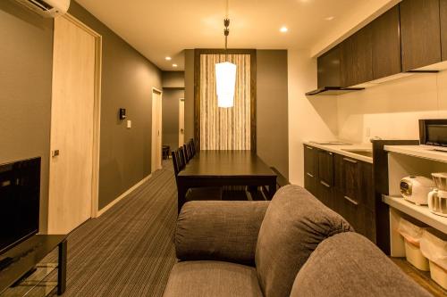 a living room with a couch and a table at R&Run Kyoto Serviced Apartment & Suites in Kyoto
