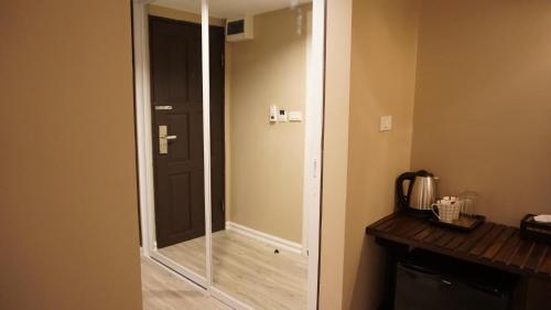 a glass door leading to a bathroom with a mirror at Taris Art Hotel Phrae in Phrae