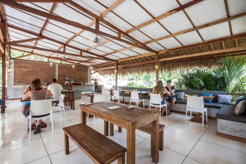 a group of people sitting in a restaurant with a table at Manta Dive Gili Trawangan Resort in Gili Trawangan