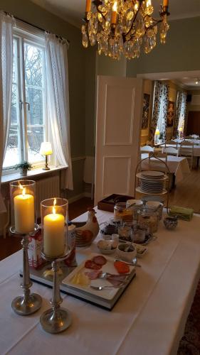 a table with candles and food on top of it at Långshyttans Brukshotell in Långshyttan
