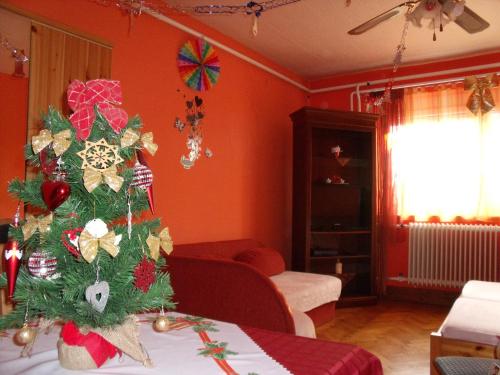 a christmas tree in the corner of a living room at Viola Vendégház in Kehidakustány