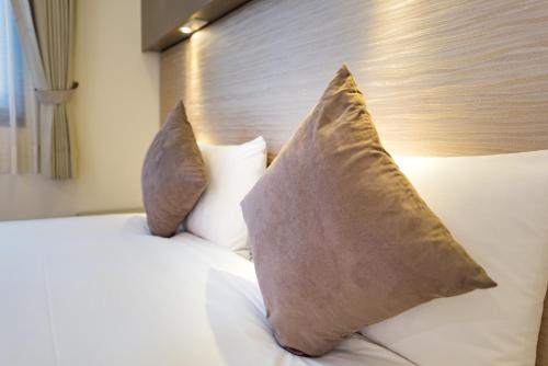 a bedroom with a bed with two pillows on it at Shin Yuan Park Hotel in Hsinchu City