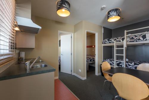 eine Küche und ein Wohnzimmer mit Etagenbetten in der Unterkunft Astray Motel in Rotorua