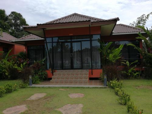 a house with glass doors and a yard at Saree Lagoon Villa Koh Samui in Lipa Noi