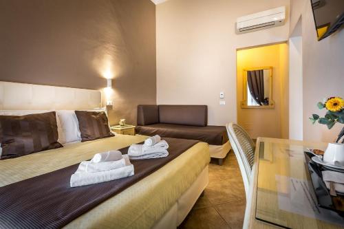 a hotel room with two beds and a couch at Sognando Firenze in Florence