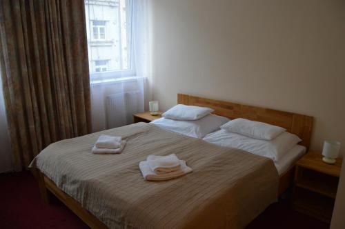 
a bed with a white comforter and pillows at HOTEL ARÉNA in Prague
