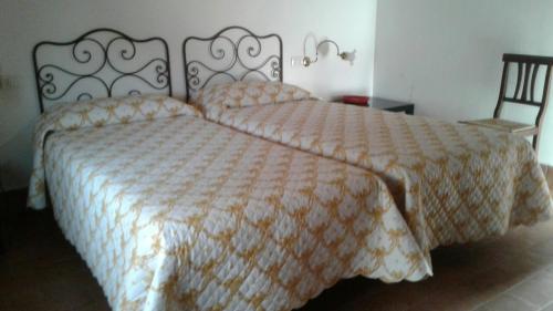 a bedroom with a large bed and a chair at Agriturismo San Bruno in San Colombano al Lambro