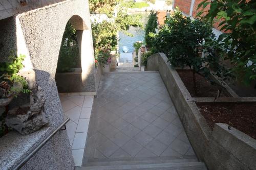 a walkway in a courtyard with plants and trees at Villa Korculaholidays in Zavalatica