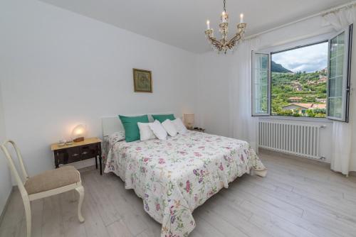 um quarto branco com uma cama e uma janela em Casa Amelia em Finale Ligure